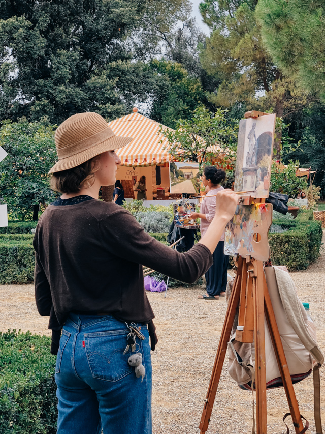 художница стоит за мольбертом в парке артократов Корсини во Флоренции Италия