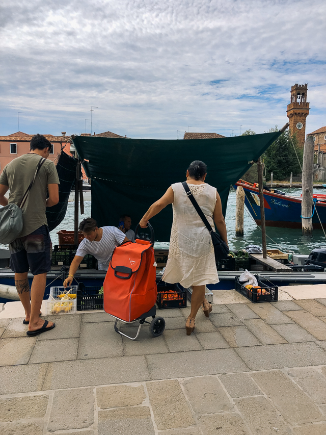 местные жители на острове Мурано покупают овощи и фрукт с лодки